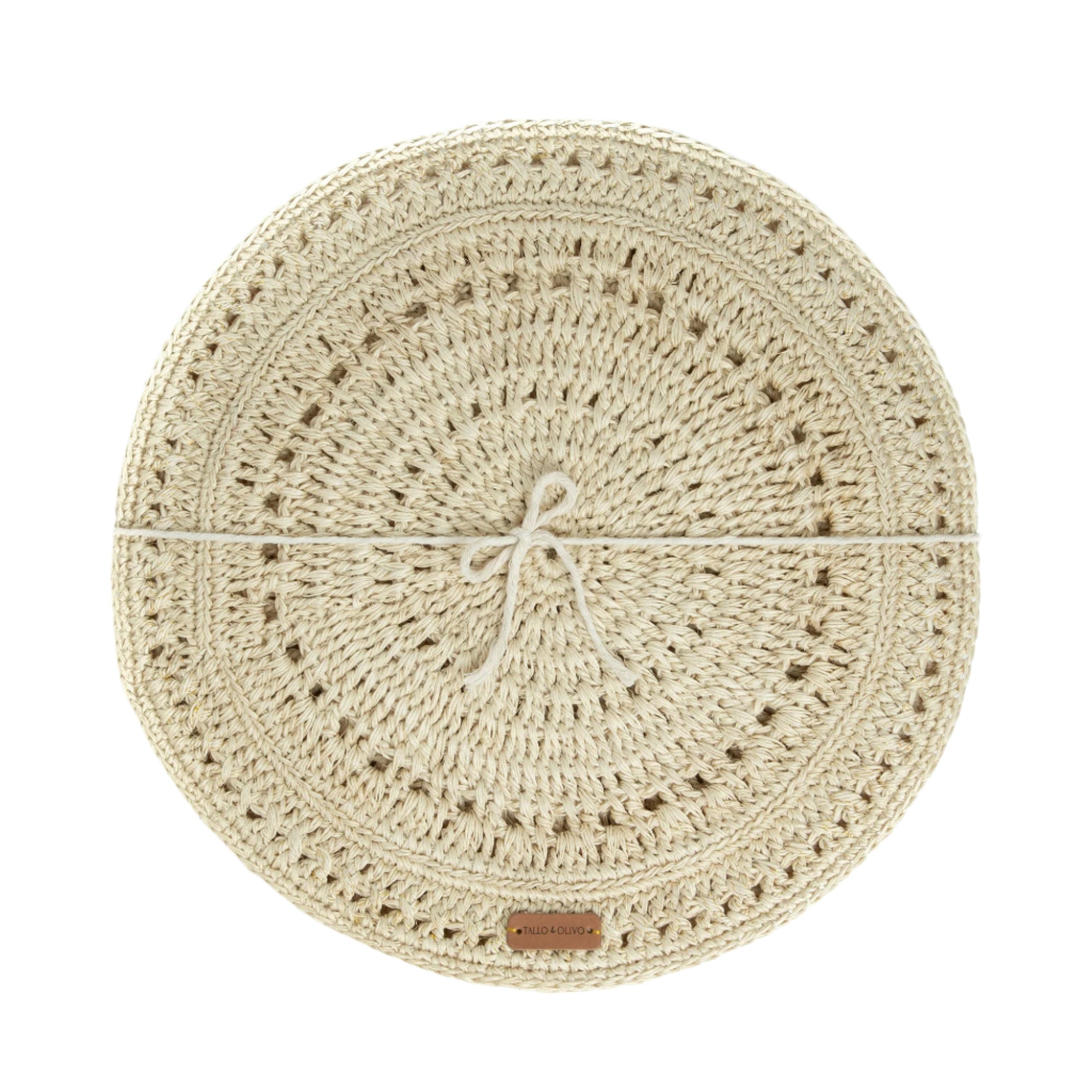 A beige, round, handwoven placemat with a spiral pattern and a label indicating the brand at the bottom