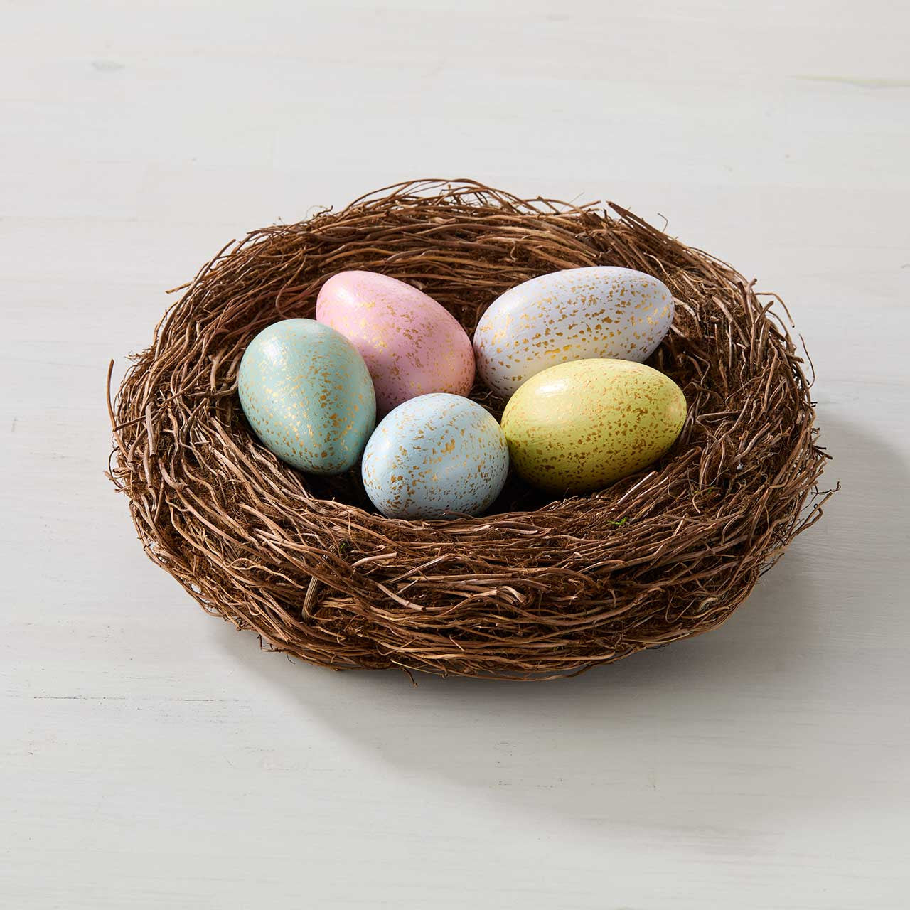 Nest with pastel-colored eggs on a light background