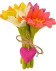 Colorful felt flowers tied together with a pink heart on a white background