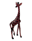 Giraffe sculpture with red and black pattern on a white background