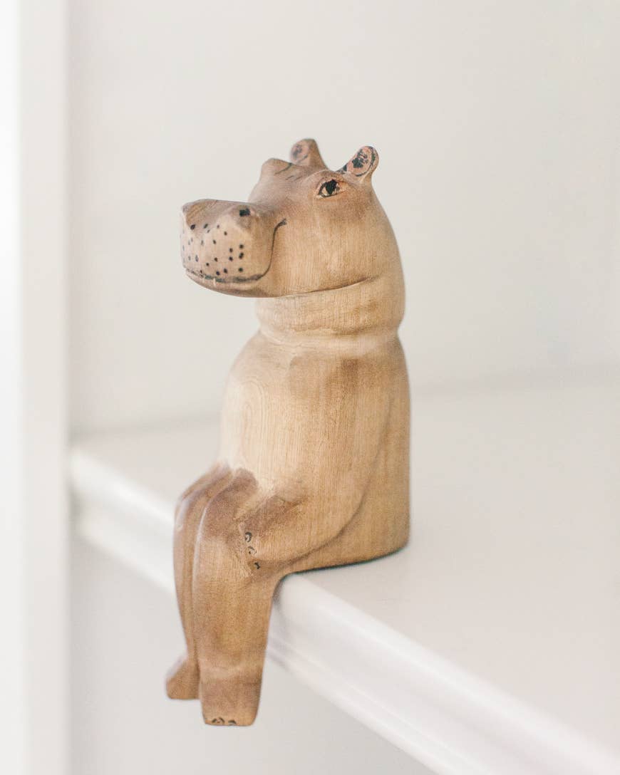 Hand painted wood hippo figurine sitting on a shelf
