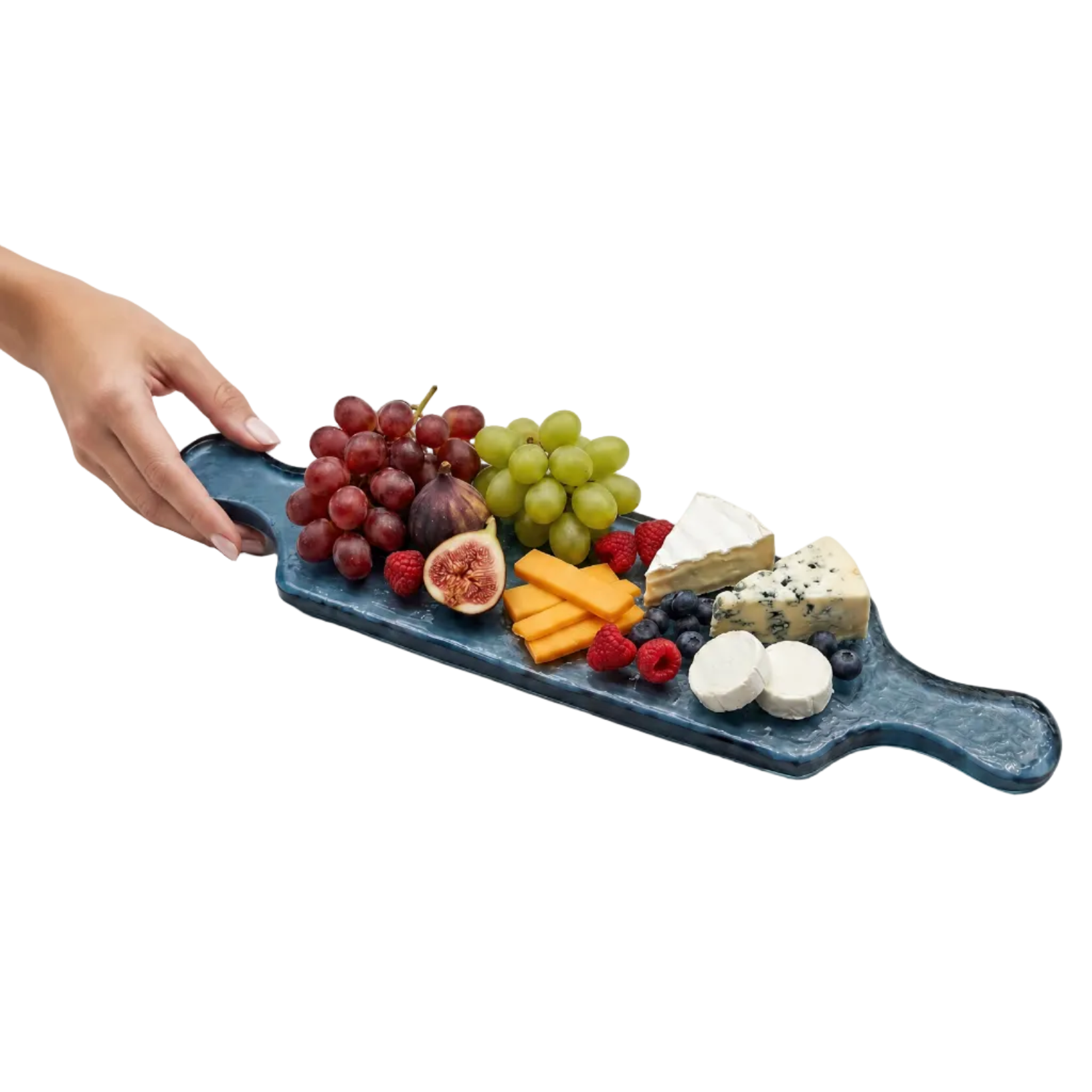 Fruit and cheese platter on a blue glass serving board held by a hand against a white background