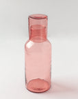 Pink glass carafe on a white background