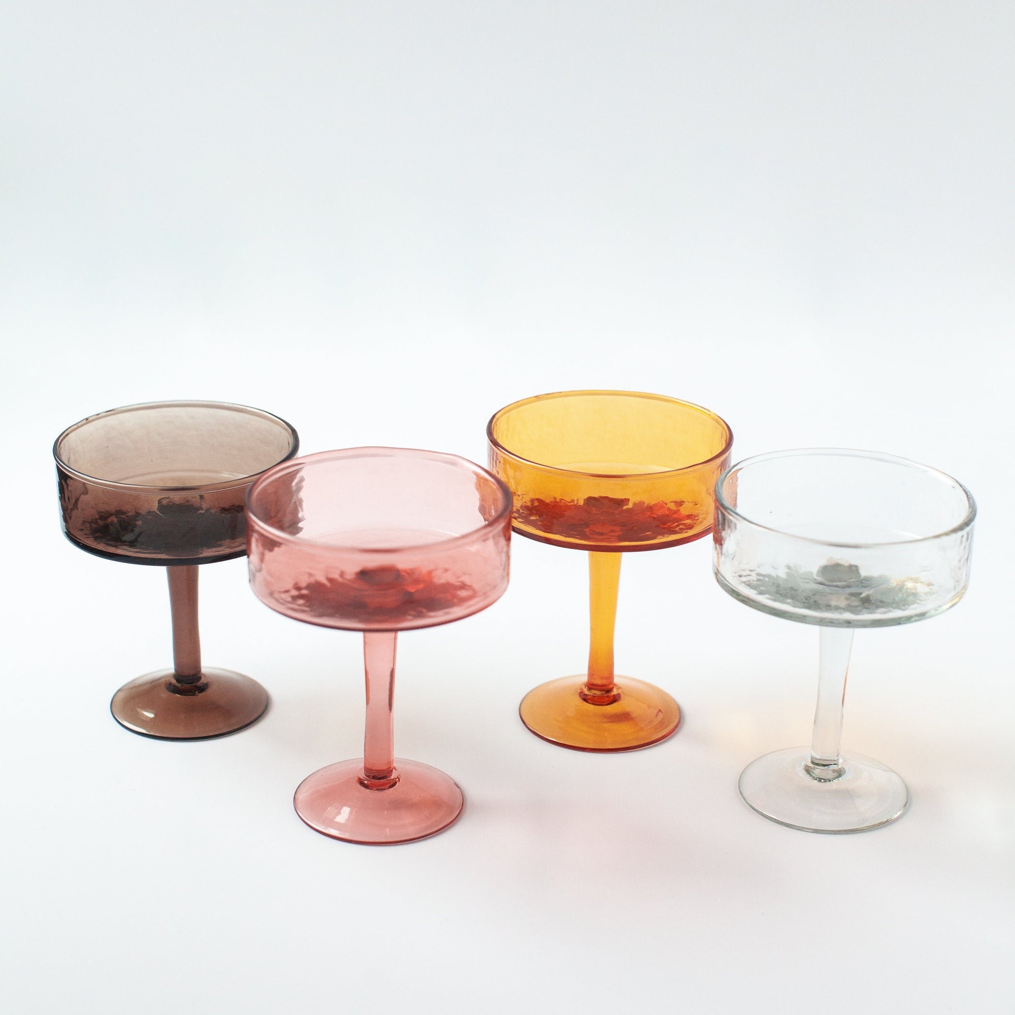 Four colorful cocktail glasses on a white background
