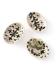 Three ceramic plates with black floral patterns on a white background