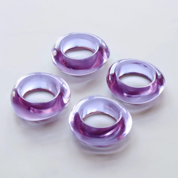 Four purple napkin rings on a white background