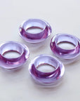 Four purple napkin rings on a white background