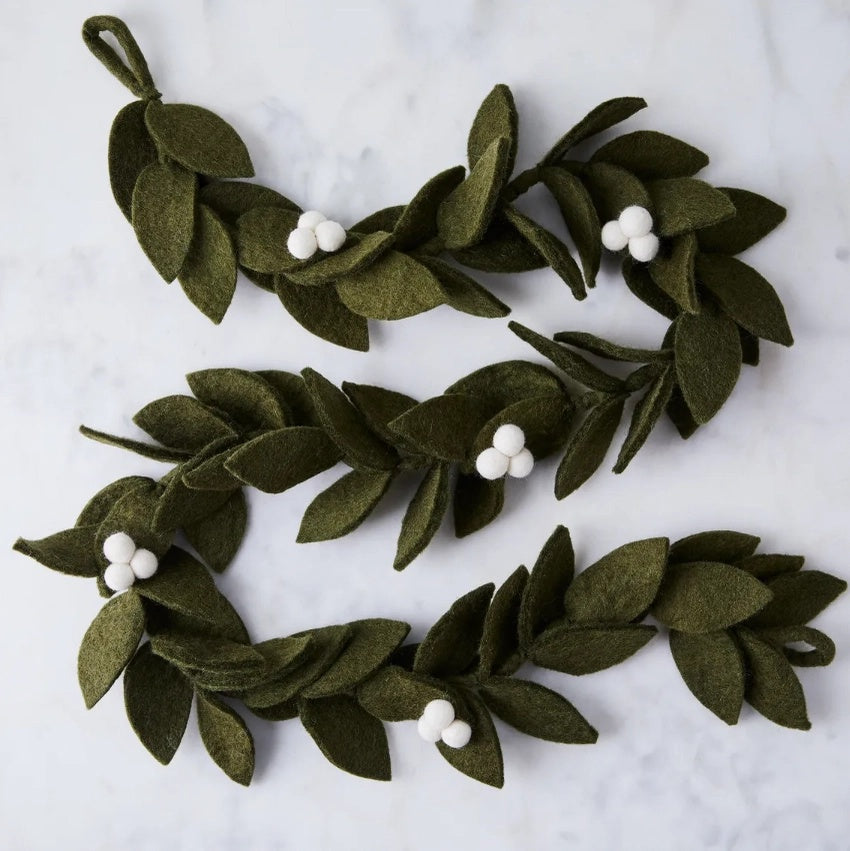 Two green leaf garlands with white berries on a light gray background