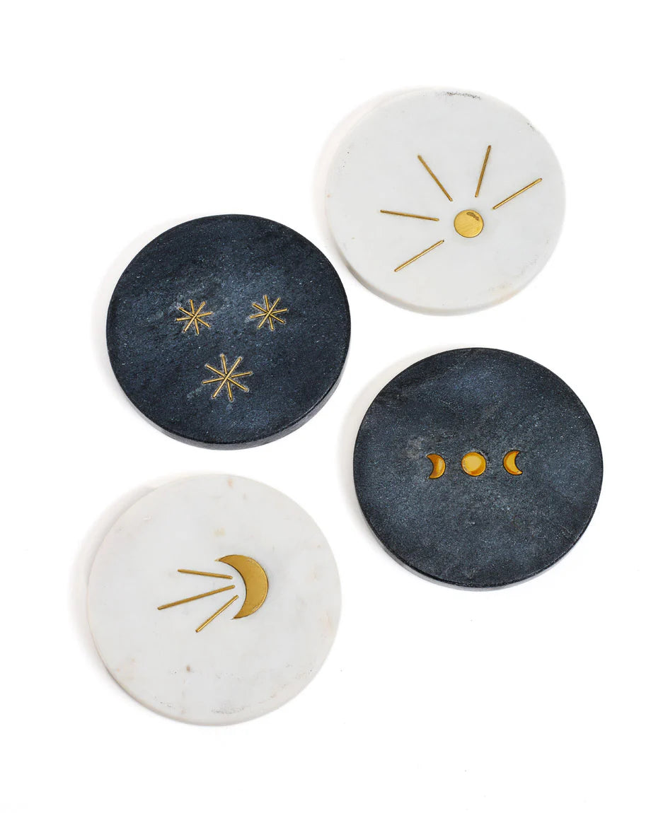 Set of four decorative coasters with celestial designs on a white background