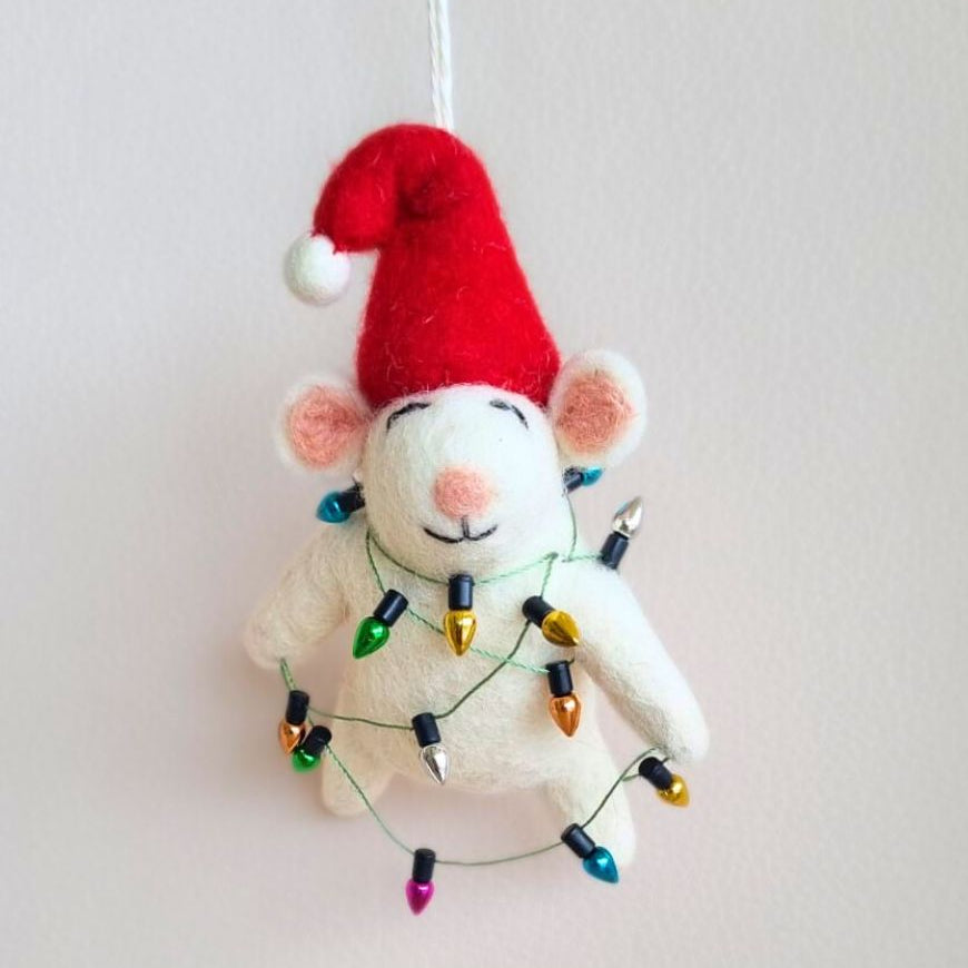 White mouse ornament with red Santa hat and string of lights on a plain background