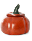 A glossy ceramic pumpkin-shaped container with a matching lid and a dark green stem, shown on a plain white background.