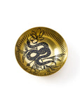 Gold decorative plate with snake and lotus design on a white background