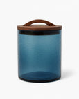 Blue storage jar with a wooden lid on a white background