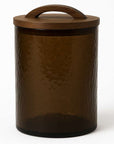 Brown glass canister with wooden lid on a white background