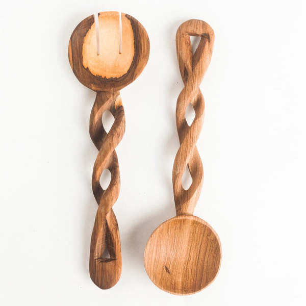 Two olive wood salad servers with twisted handles on a white background