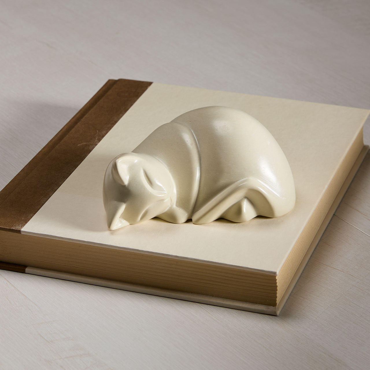 White stone cat figurine on a book cover.