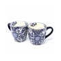 A set of two traditional Mexican pottery mugs with blue floral patterns on a white background