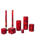 Set of red patterned candles on a white background