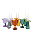 Colorful glassware with candles on a white background