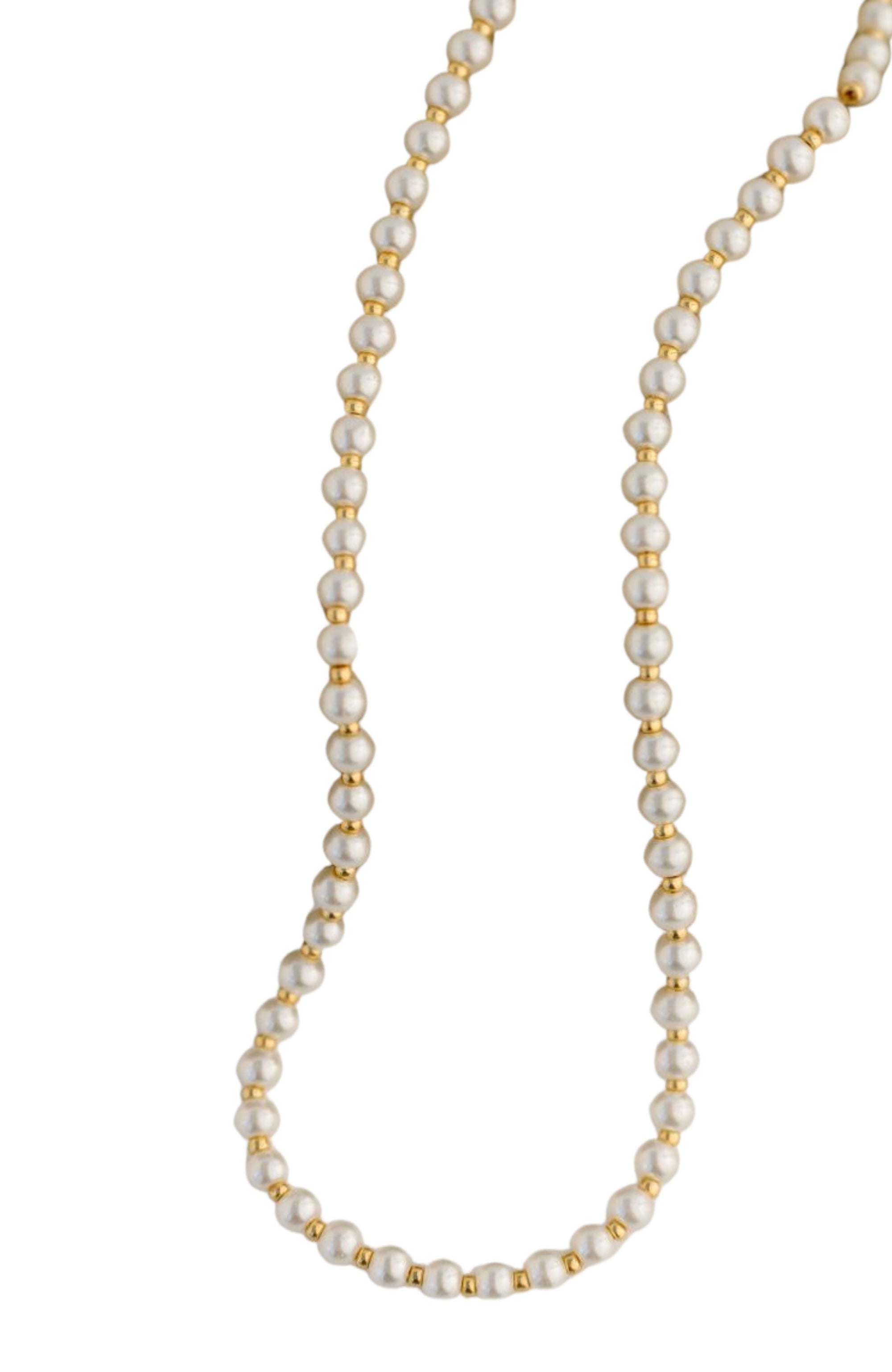 Pearl necklace with gold accents on a white background