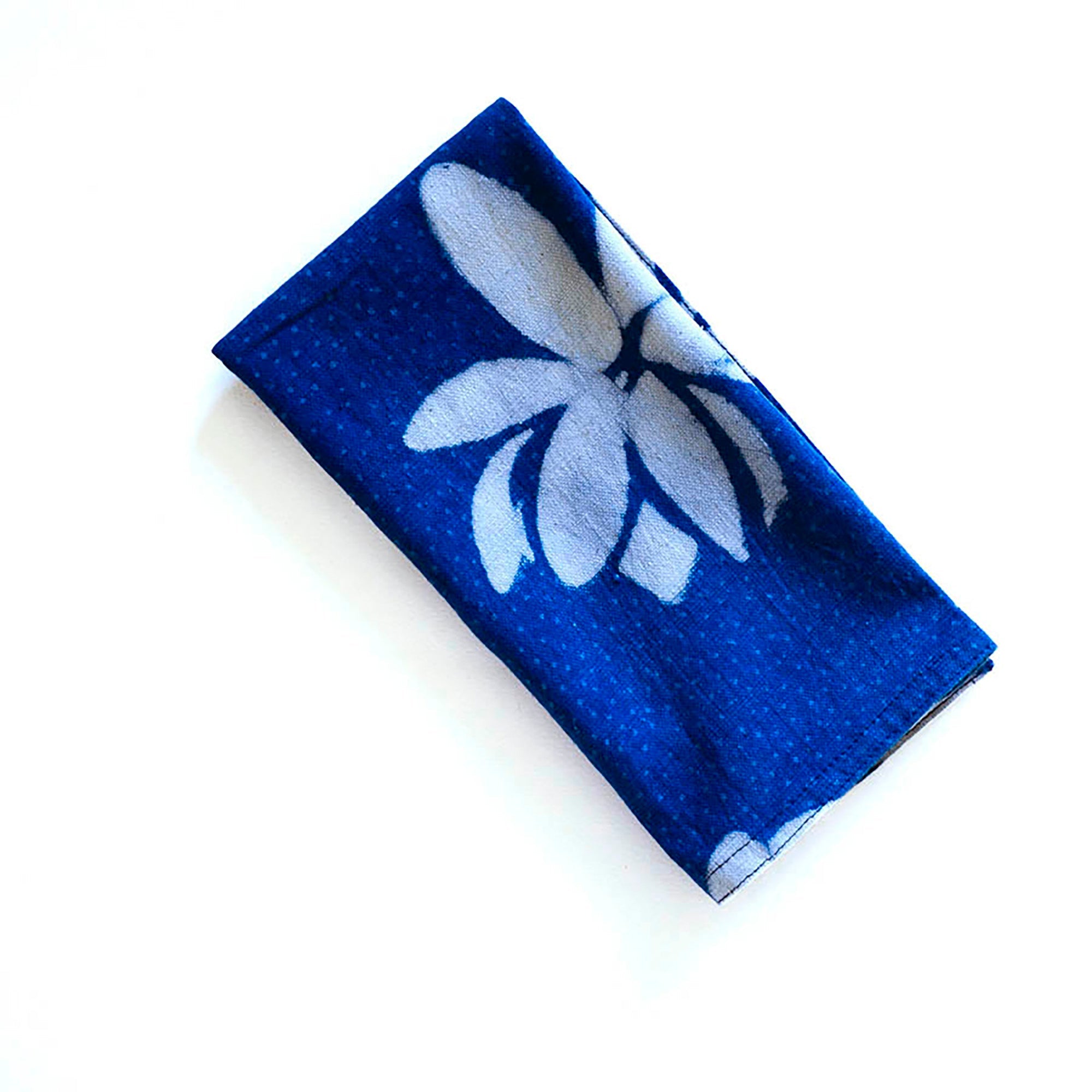 Blue fabric with white floral lotus design on a white background