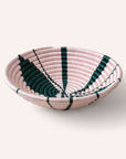 Woven bowl with pink and green pattern on a white background