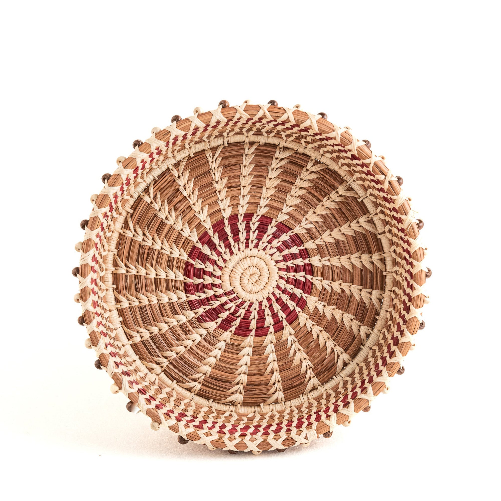 Woven basket with a spiral pattern on a white background