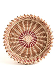 Woven basket with a spiral pattern on a white background