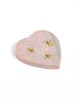 Heart-shaped marble incense holder with gold star designs on a white background