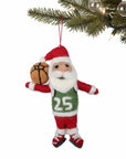 Santa Claus ornament holding a basketball hanging from a christmas tree branch