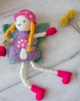 Blonde mushroom bonnet tooth fairy pillow with pink boots and a purple dress displayed on a light surface.