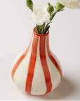Three colorful striped vases with flowers on a white background
