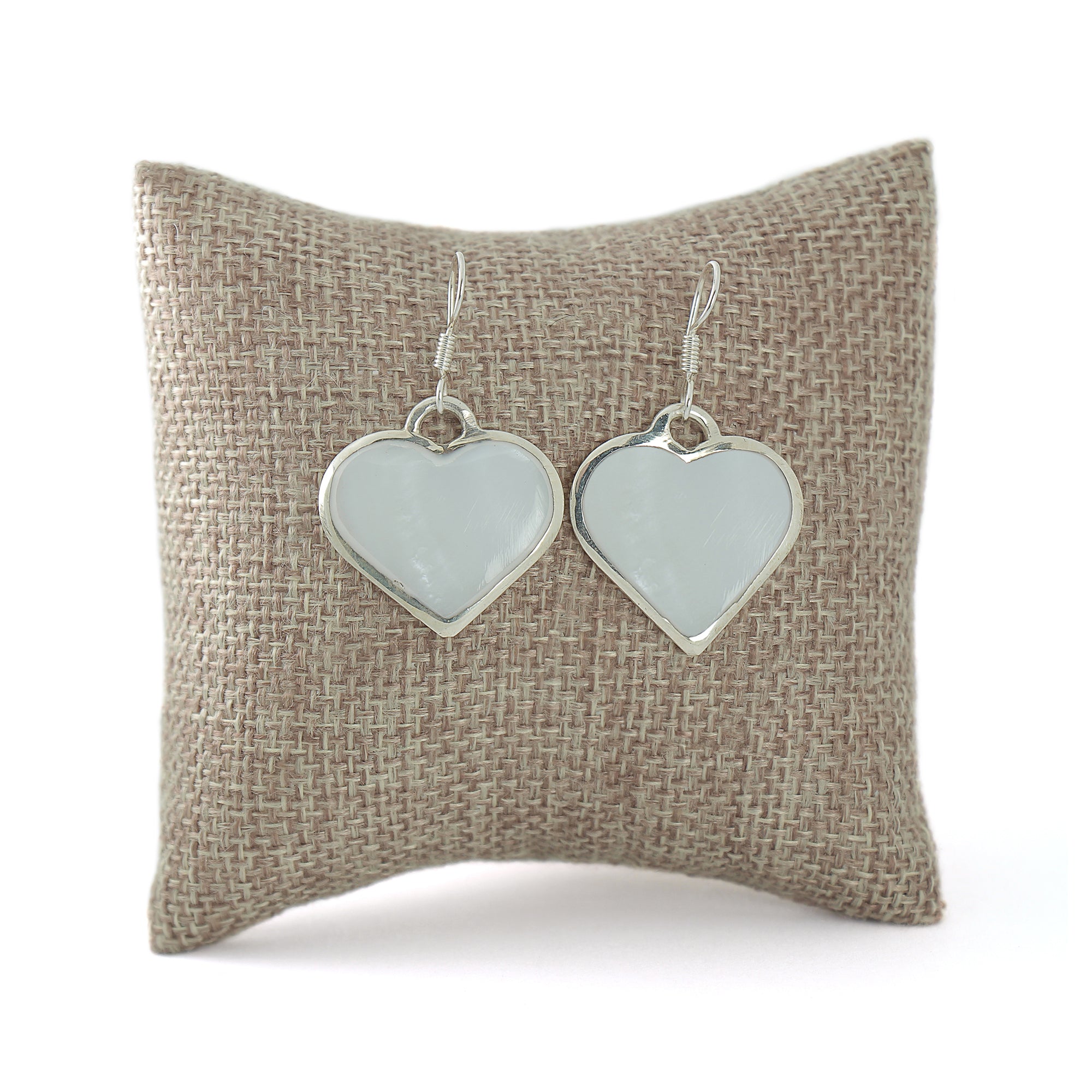 Sterling silver Mother-of-Pearl shell earrings made with gemstone displayed on a pillow