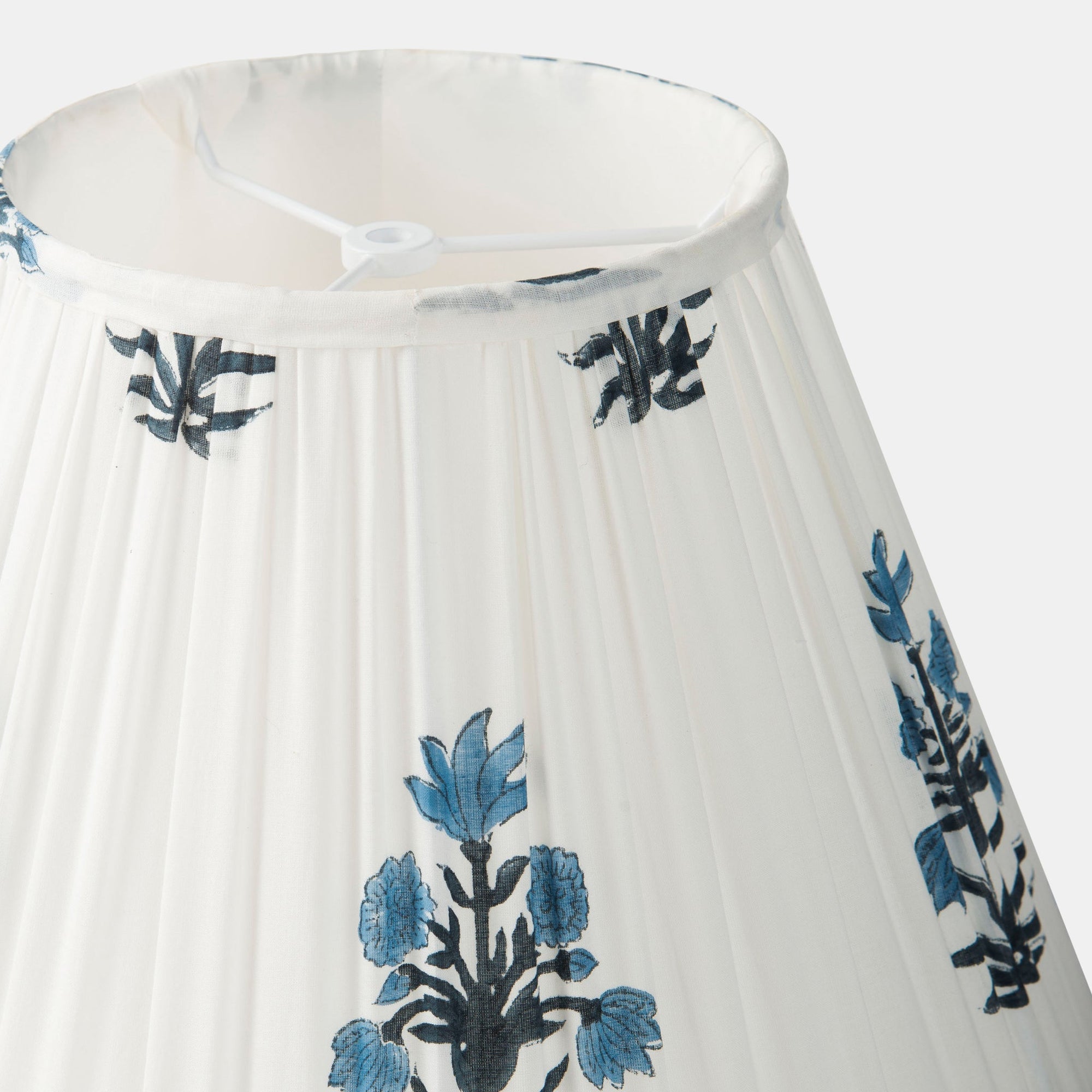 White pleated lamp shade with blue floral embroidery on a white background