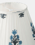 White pleated lamp shade with blue floral embroidery on a white background