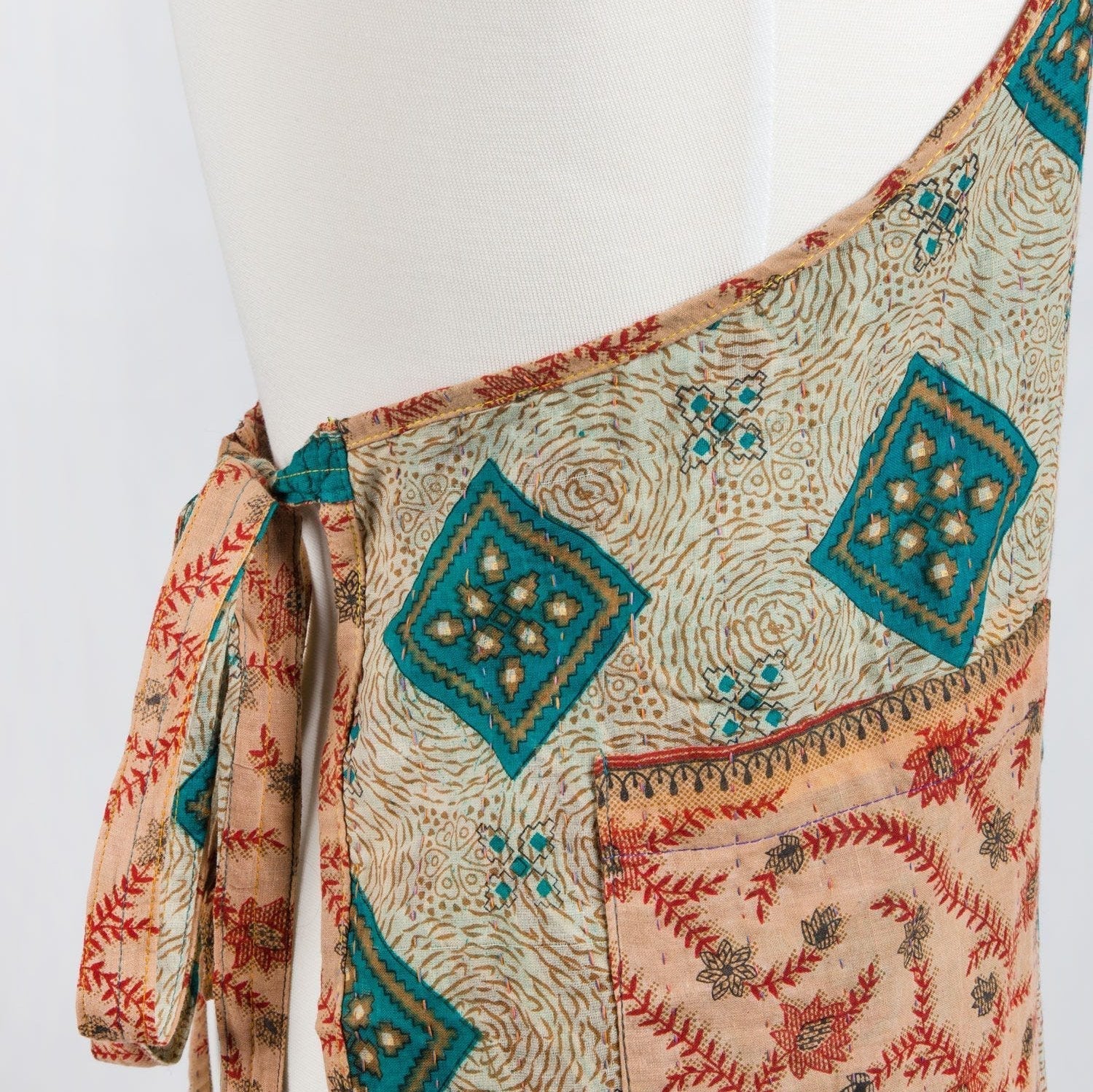 Traditional patterned apron on a mannequin against a white background