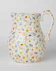 Ceramic pitcher with floral pattern on a light gray background