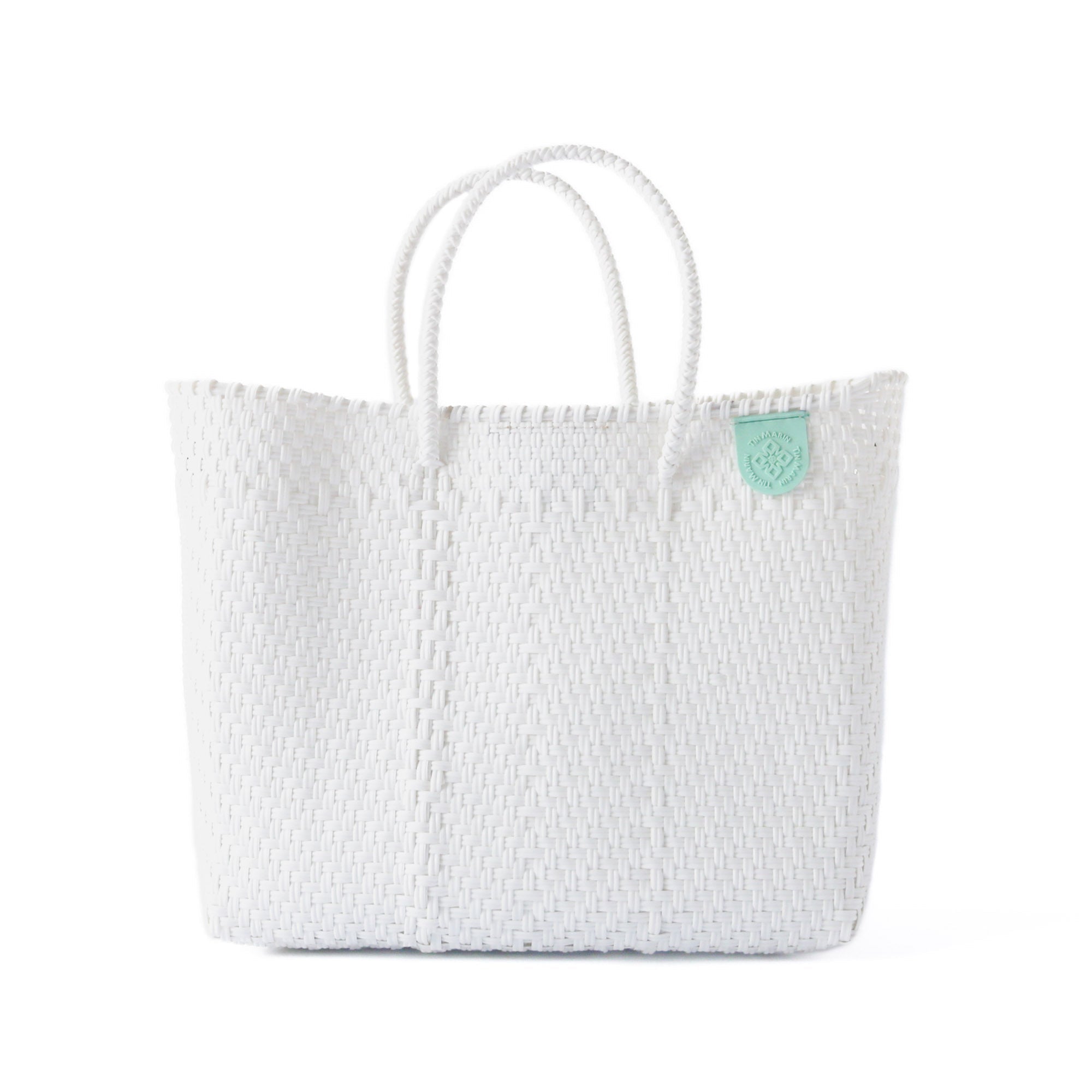 White textured tote bag with a green tag on a white background