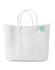 White textured tote bag with a green tag on a white background