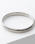 Silver bracelet on a white surface