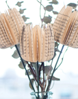 Decorative flowers made from book pages in a vase with a blurred background