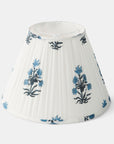 White pleated lampshade with blue floral patterns on a white background