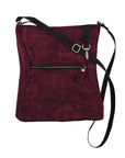 Maroon crossbody purse with black strap on a white background