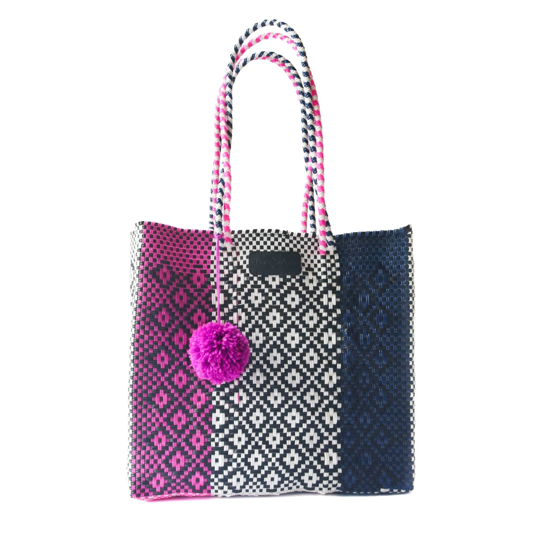 Tote bag with pink pom-pom, black and white pattern, and pink handle on a white background