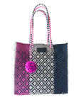 Tote bag with pink pom-pom, black and white pattern, and pink handle on a white background