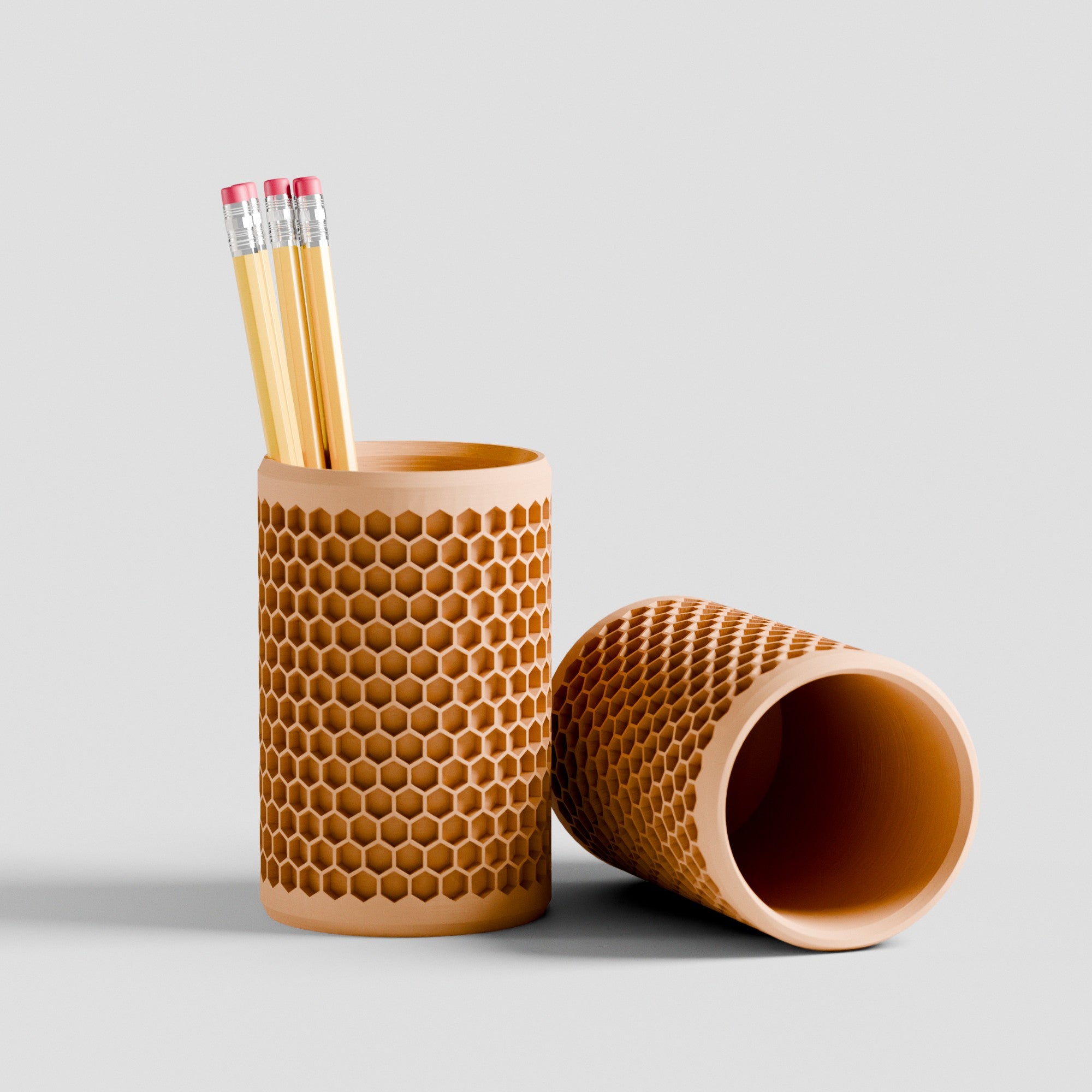 Pencil holder with honeycomb pattern containing pencils on a light gray background