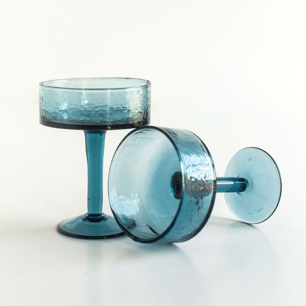 Two blue cocktail glasses on a white background