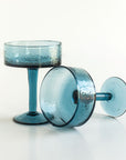 Two blue cocktail glasses on a white background