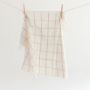 Windowpane checkered hand towel hanging on a clothesline against a white background