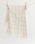 Windowpane checkered hand towel hanging on a clothesline against a white background